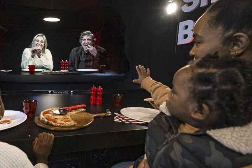 Một người đang xem hình đại diện ba chiều AI kích thước thật bên trong phòng trưng bày.